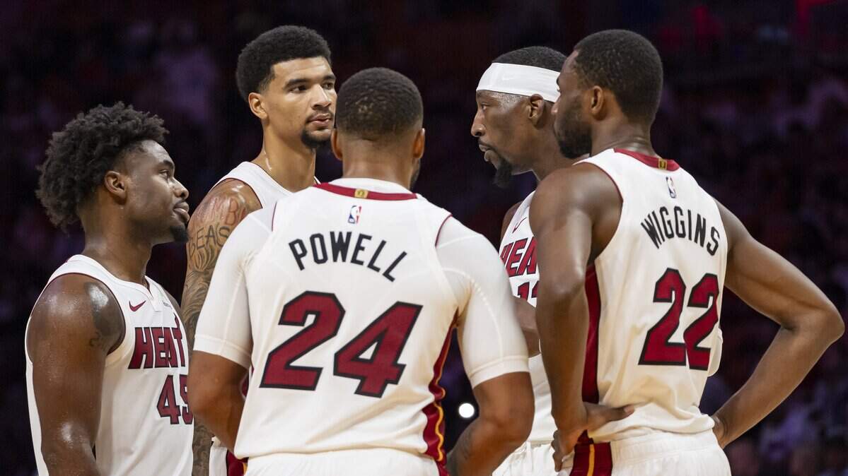 Miami Heat guard Davion Mitchell (45), Kel'el Ware (45), Norman Powell (24), Bam Adebayo (13) and Andrew Wiggins (22) huddle as they play against the Memphis Grizzlies in the second half of their NBA preseason game at Kaseya Center on Oct. 17, 2025, in Miami.